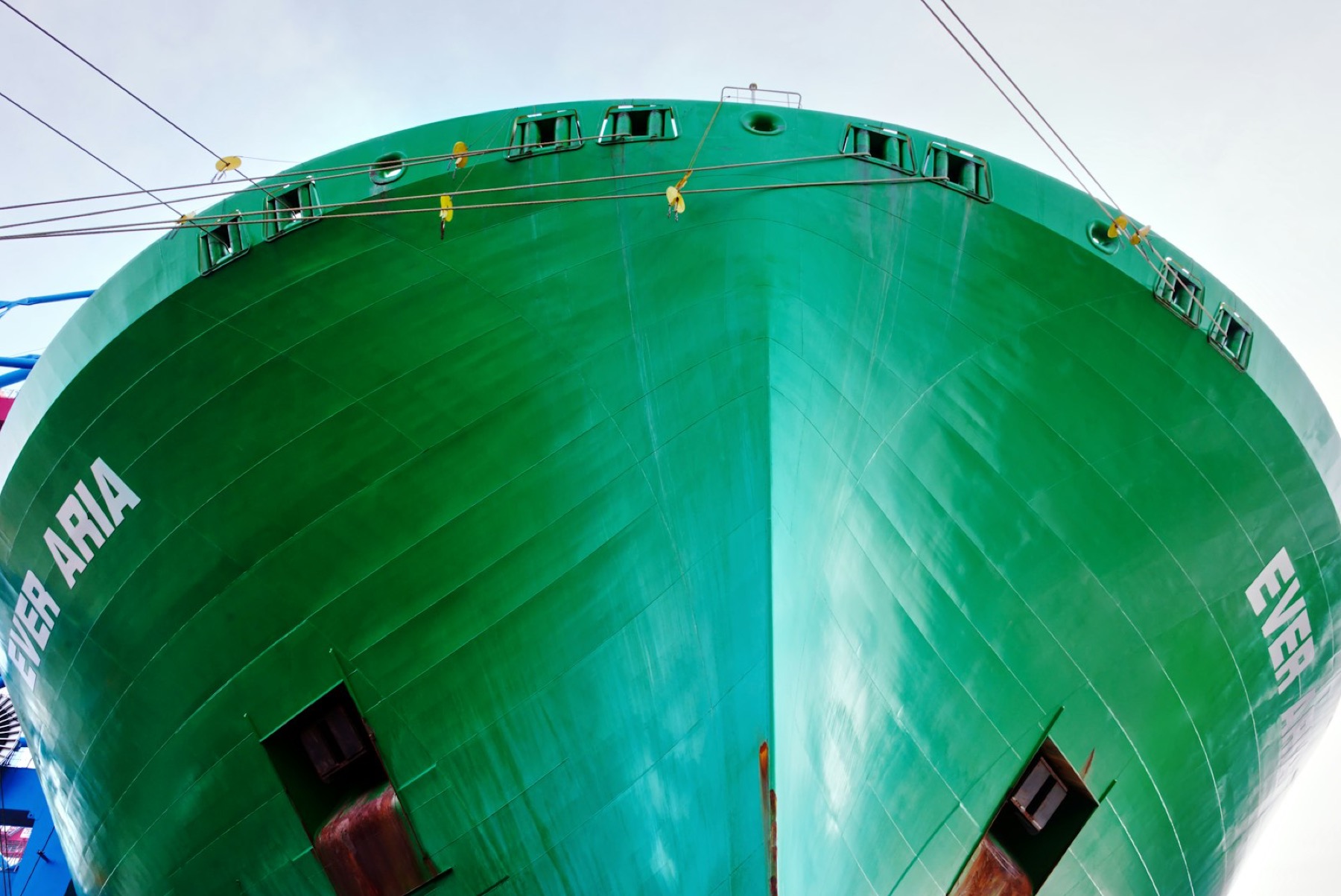 Close view of a large green cargo vessel bow at berth