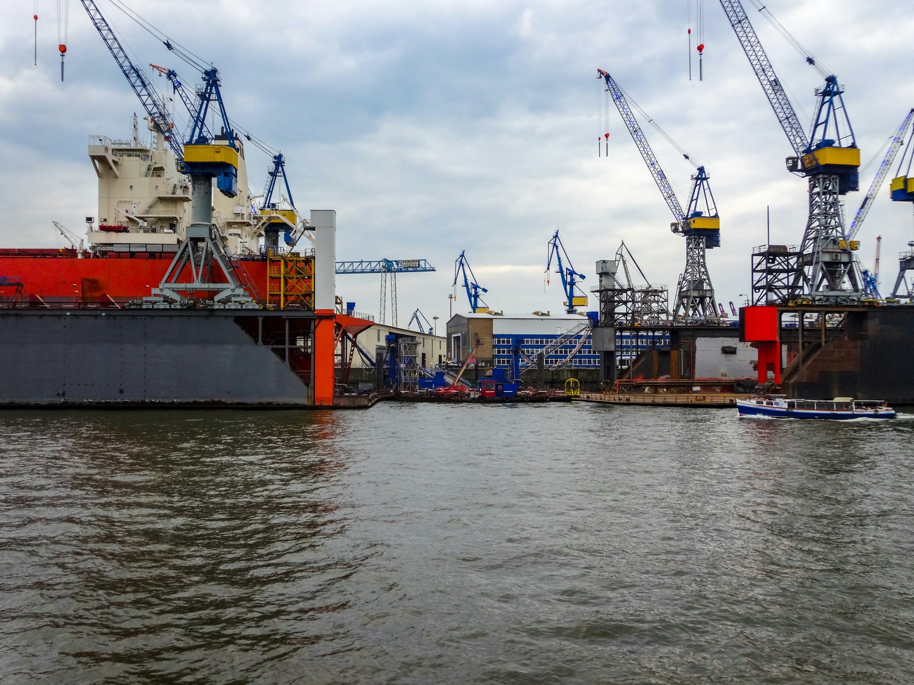 Commercial vessel in shipyard maintenance with cranes and vessel equipment
