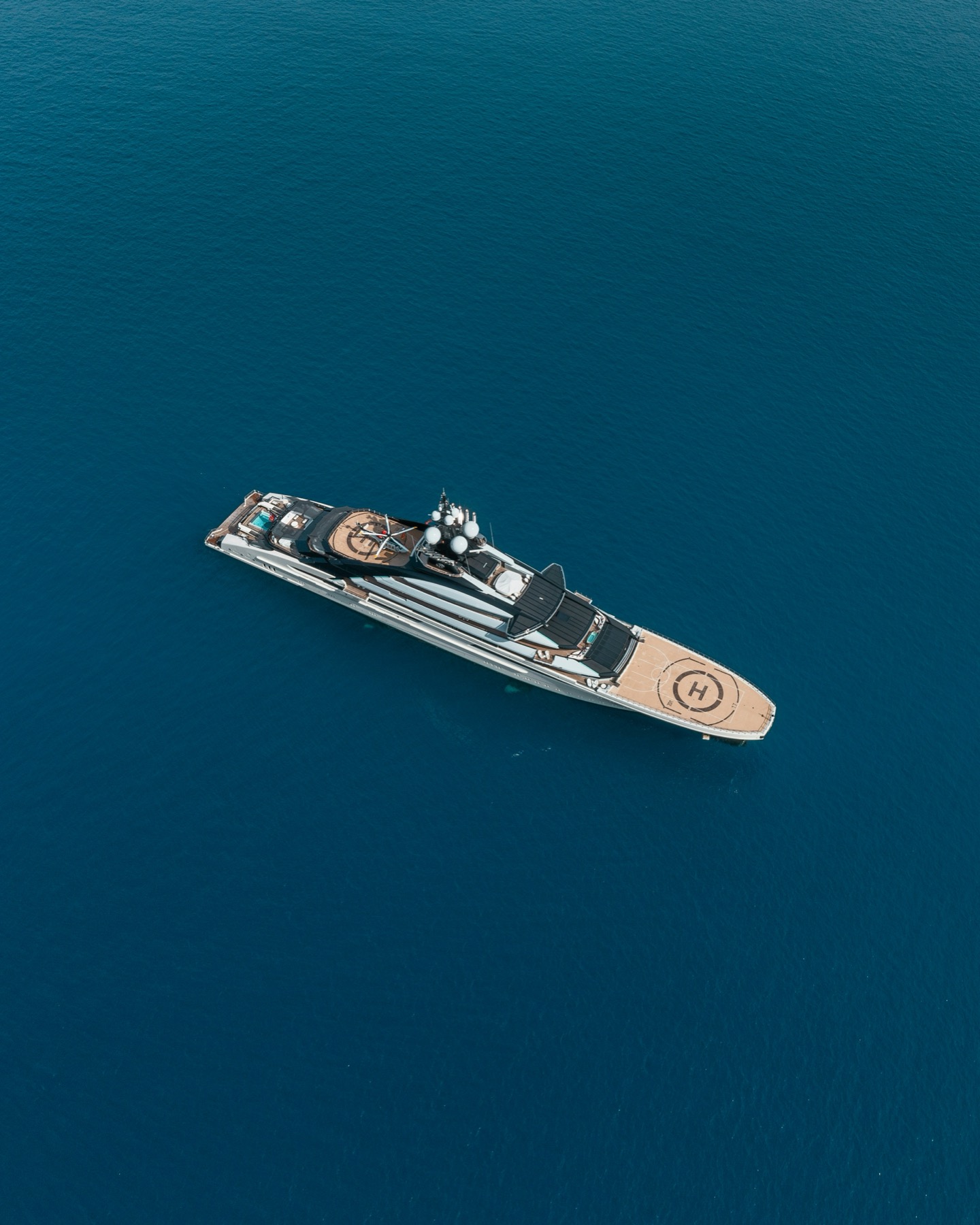 Aerial view of a large superyacht underway, representing privately operated vessels over 500 GT