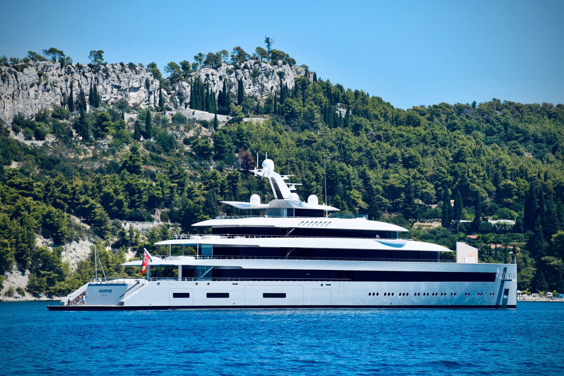 Large yacht underway near a rocky coastline