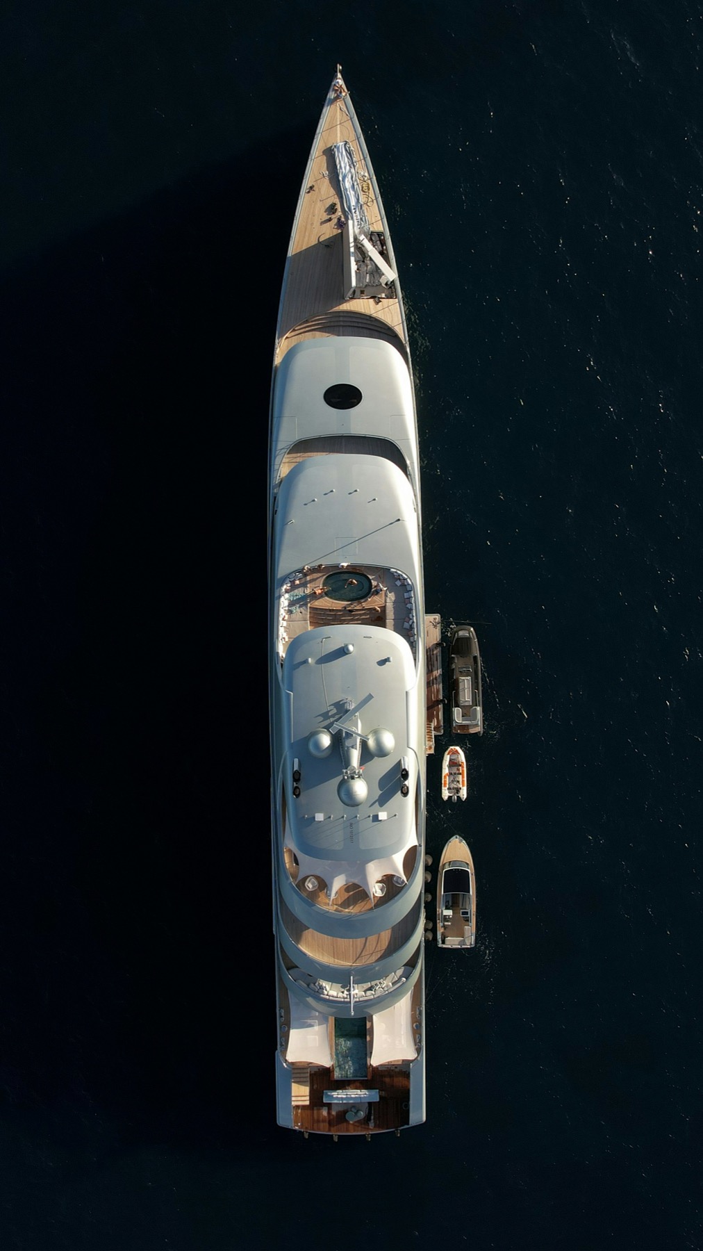 Top-down view of a large yacht and tender alongside